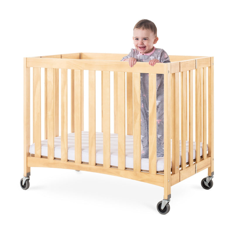 Foundations Travel Sleeper Compact Folding Wood Crib with 2" Foam Mattress and Oversized Casters - Natural